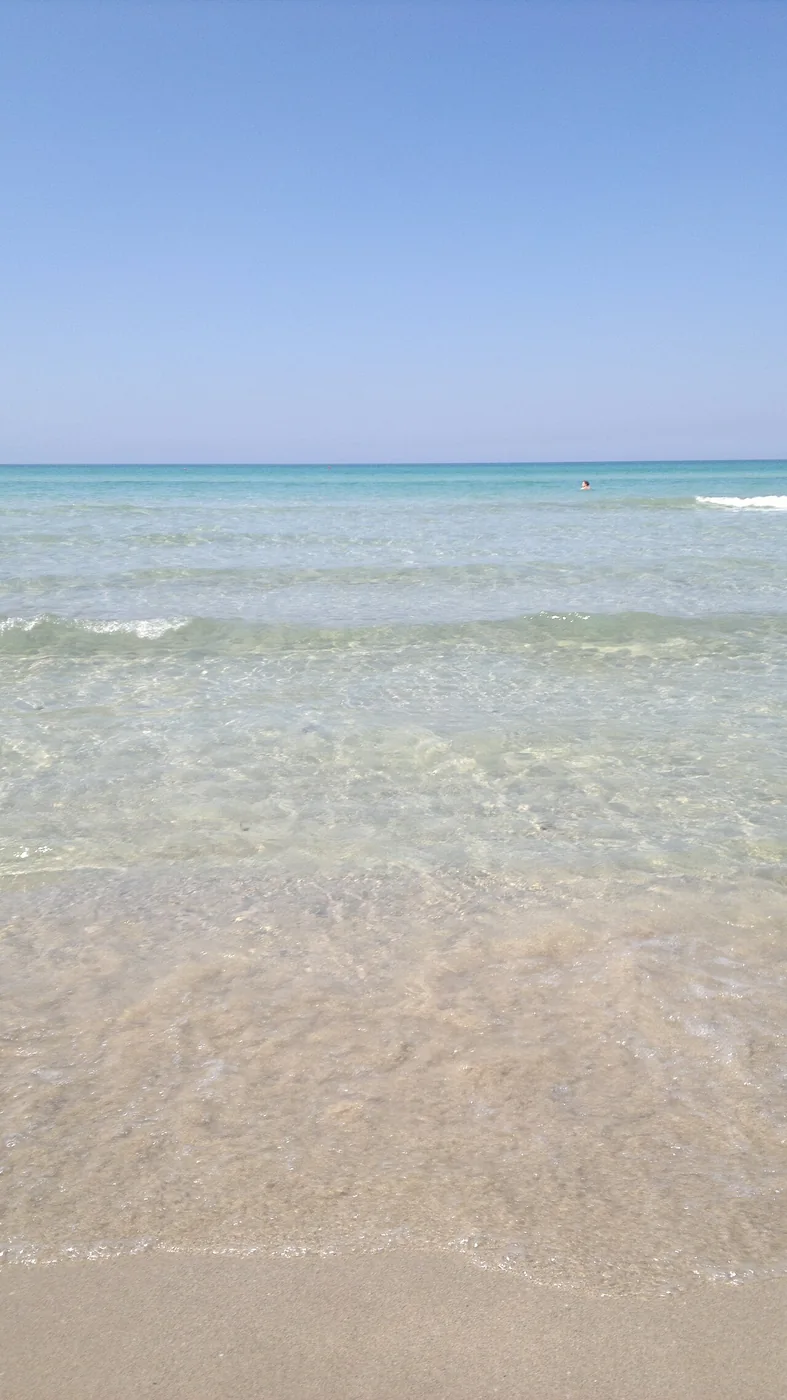 Klares Wasser am flachen Sandstrand von Pescoluse.