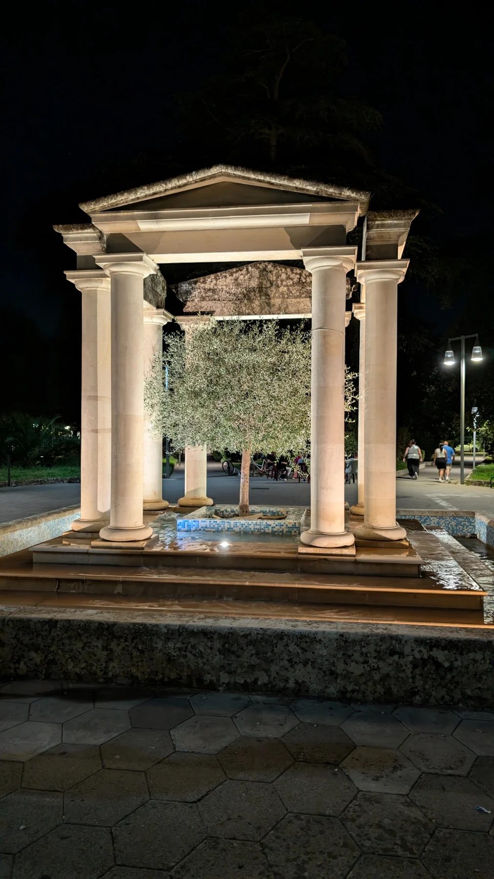 Ein beleuchtetes steinernes Monument mit Säulen bei Nacht